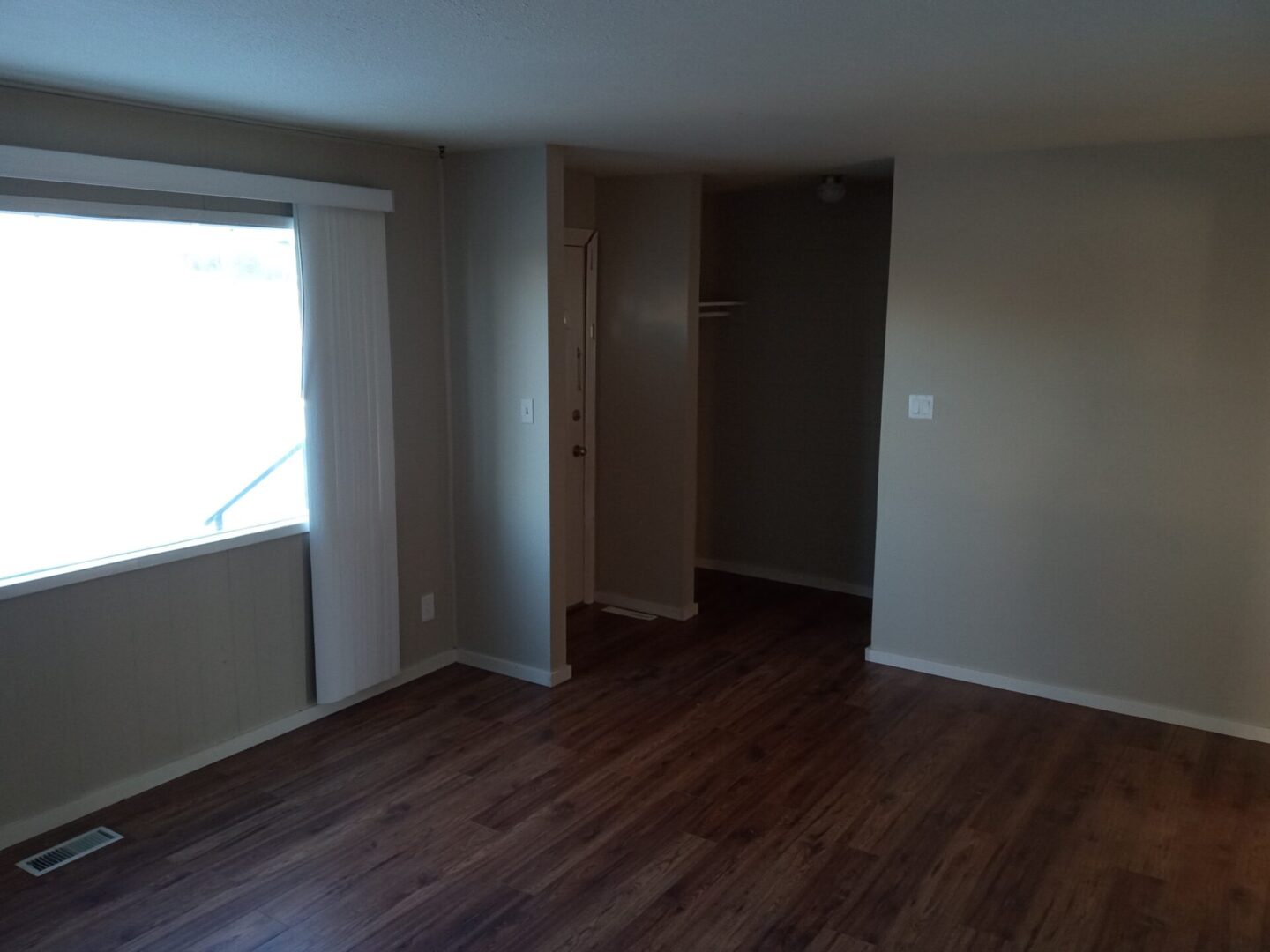 A room with hardwood floors and a window.