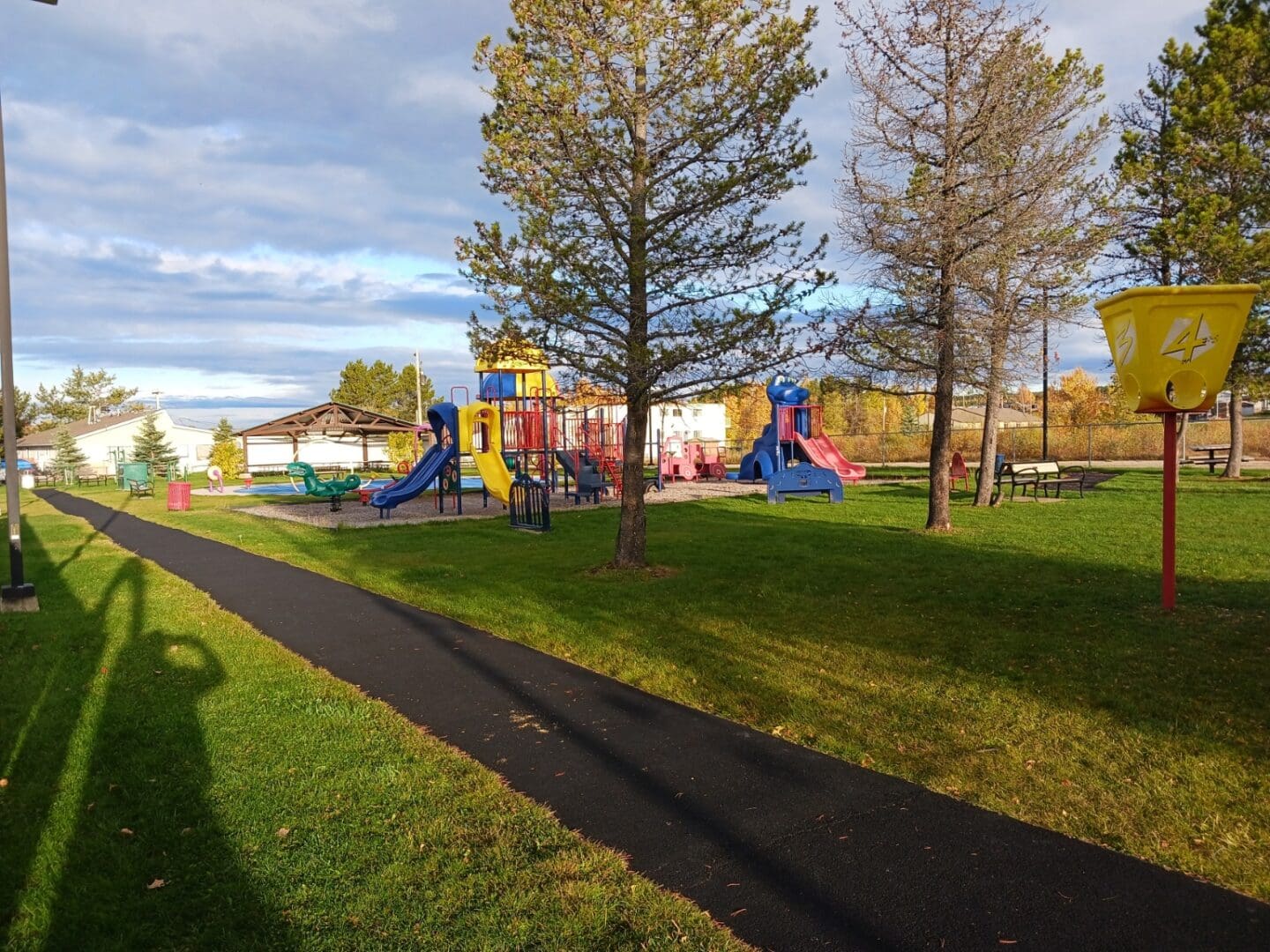 A park with many different colored slides and trees