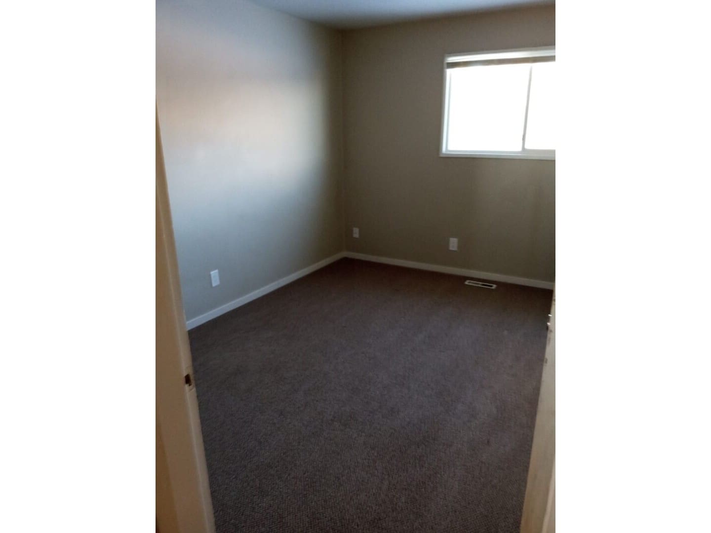 A room with a window and carpet in it