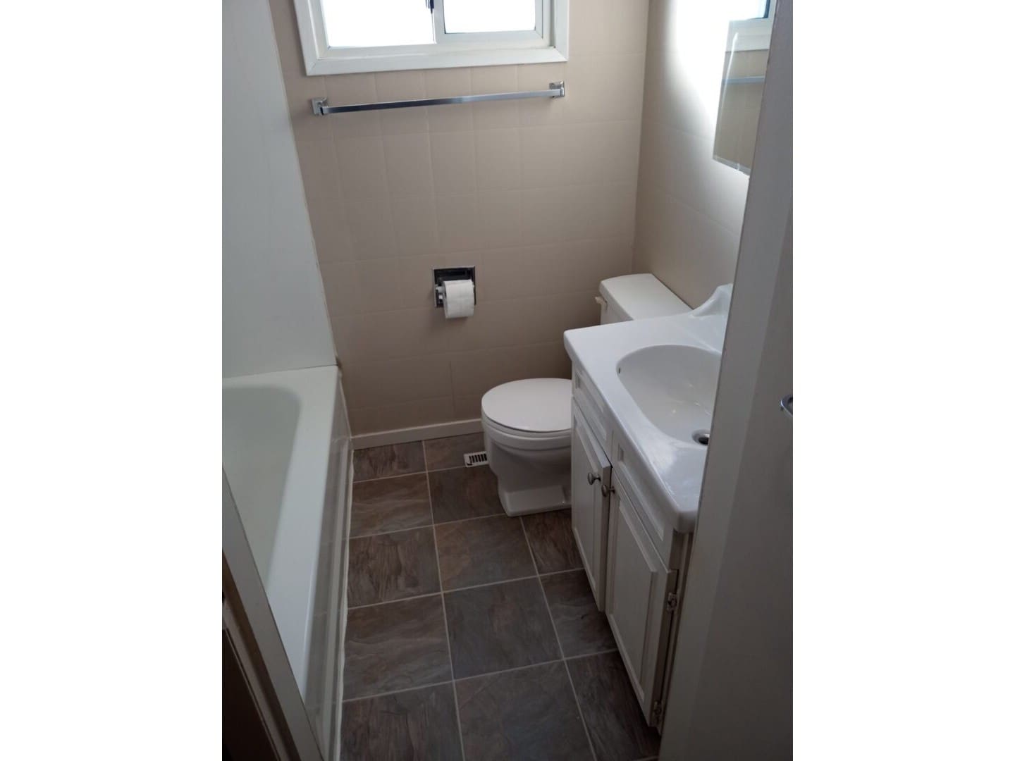 A bathroom with a toilet, sink and tub.